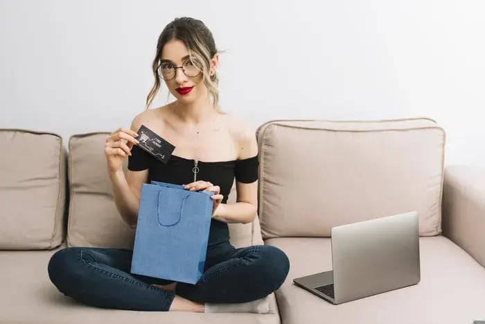Woman unboxing new eyeglasses purchased online after testing frames with virtual try-on.